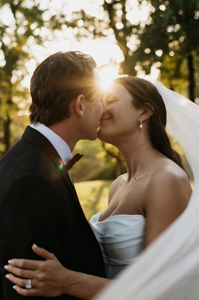 Bride and groom kissing at sunset.