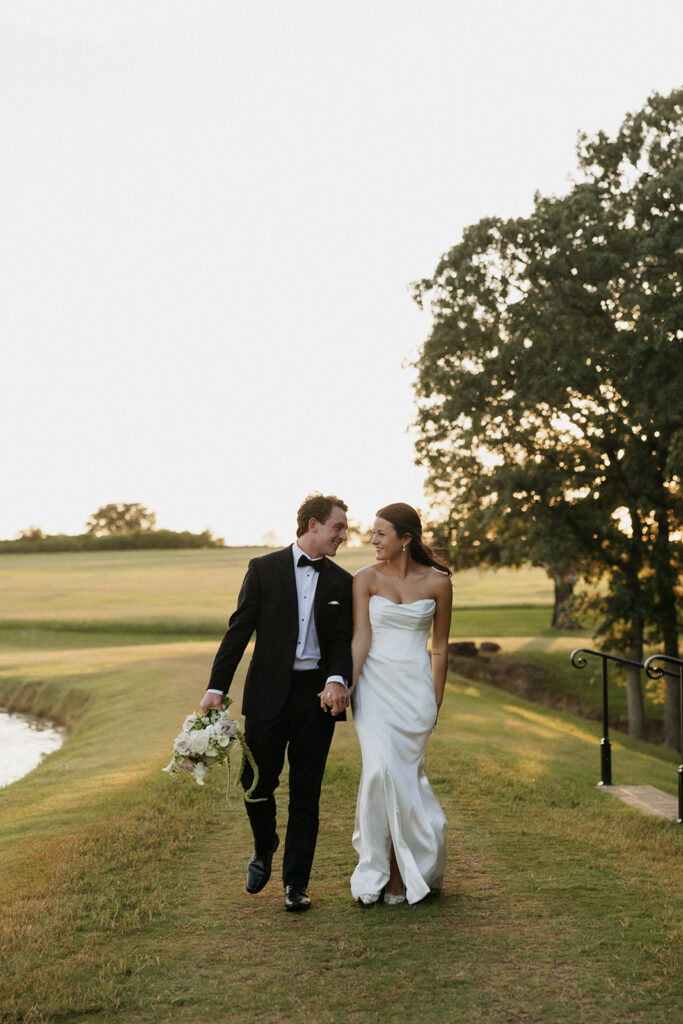 Bride and groom walking hand in hand outside their North Texas wedding venue.