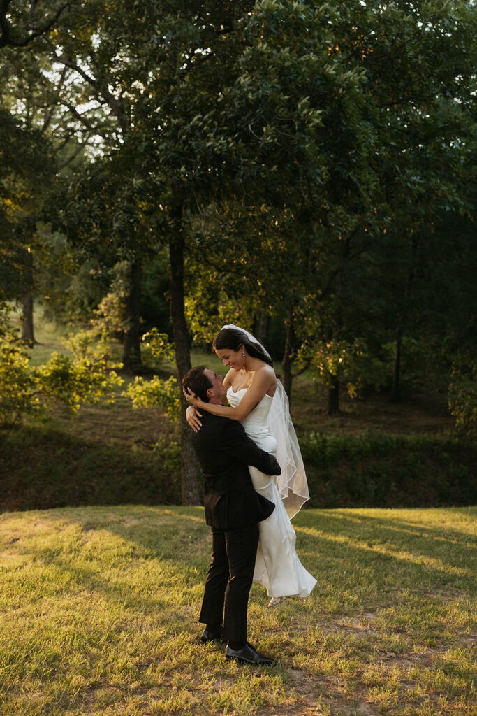 Groom holding his bride in the air.