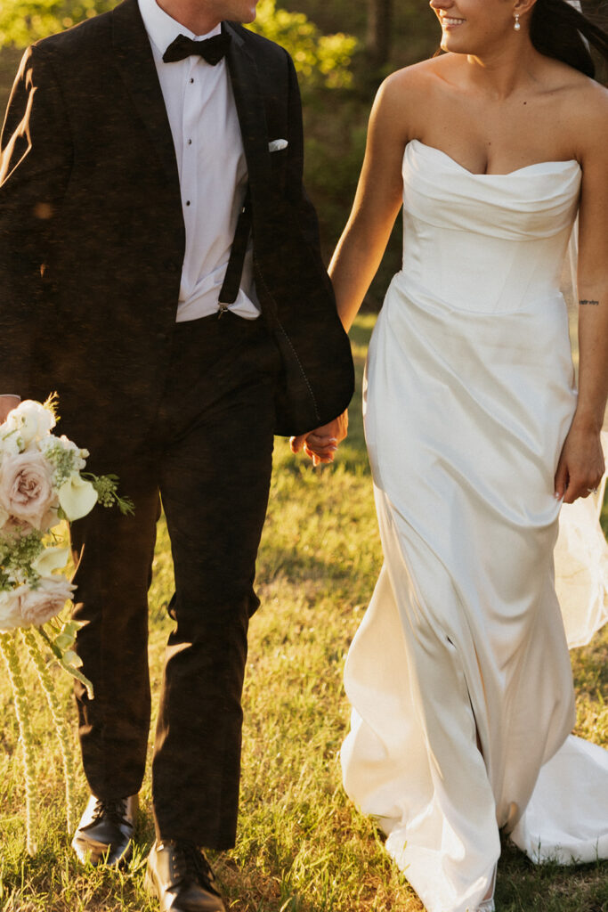 Bride and groom holding hands and walking at their Spring wedding.