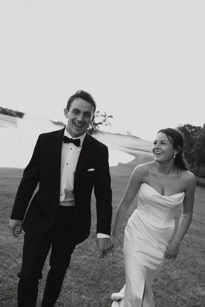 Bride and groom holding hands and laughing at their North Texas wedding venue. 