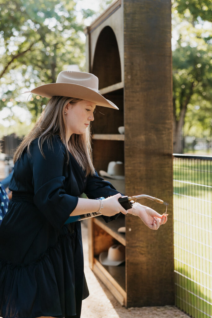 A guest customizing a hat at the western wedding hat bar.