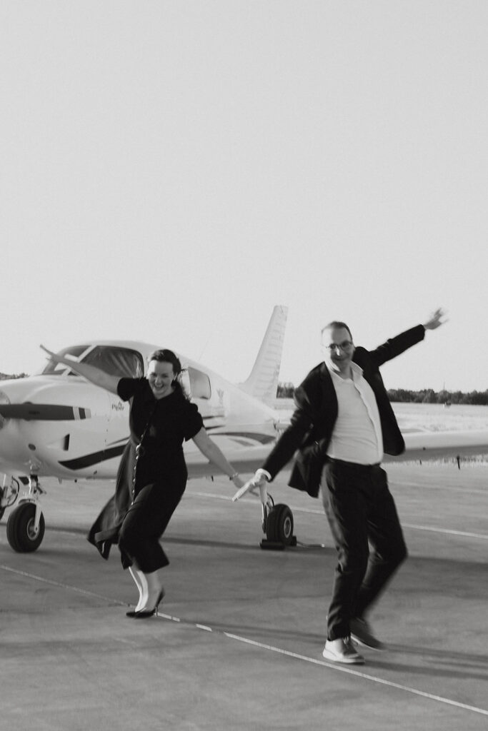 Couple pretending to be airplanes for unique engagement photos in Dallas.