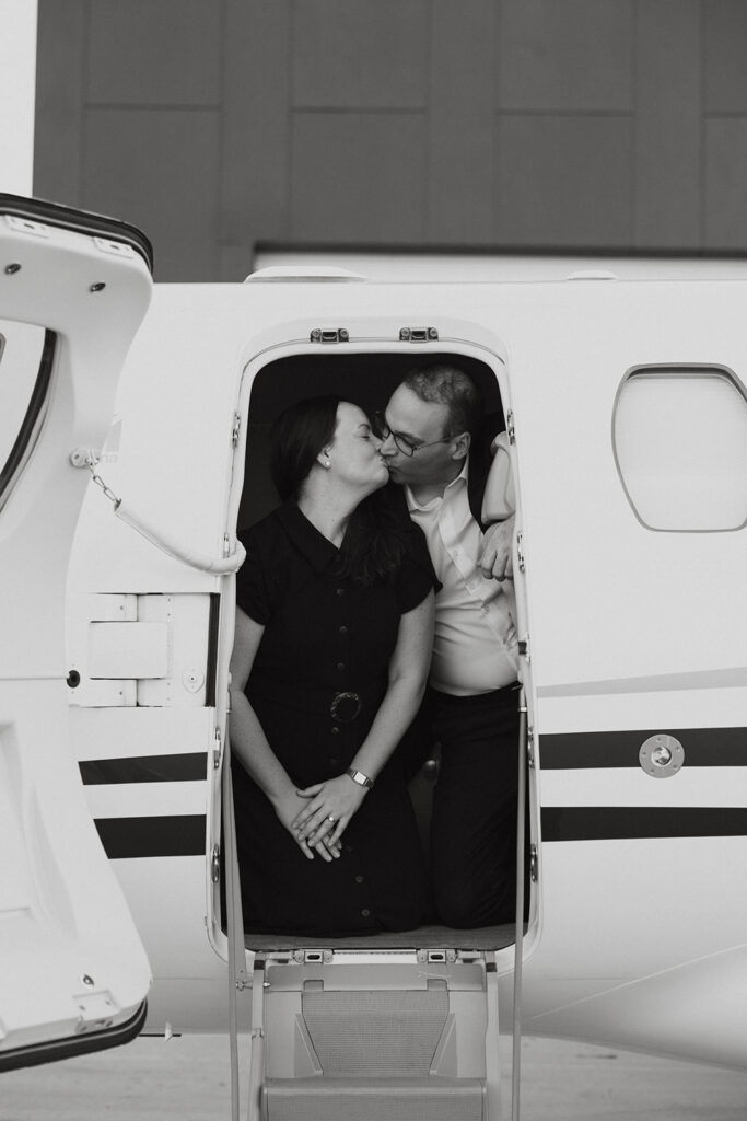 Couple kissing inside a private jet for aviation engagement photos.