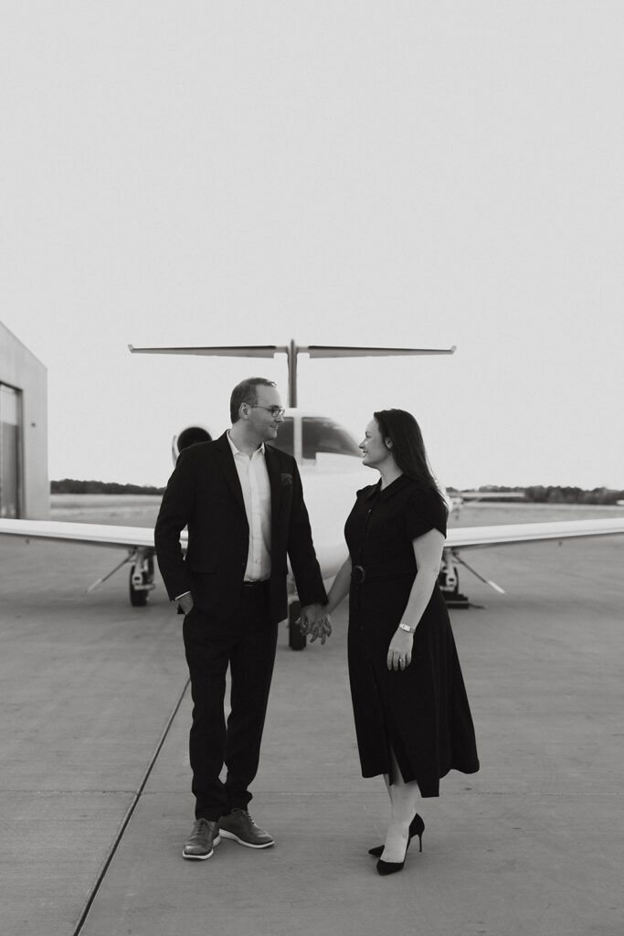 Couple standing in front of an airplane. 