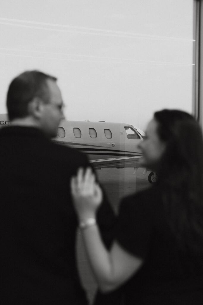 Couple looking out of a window at an airport in Dallas, Texas.