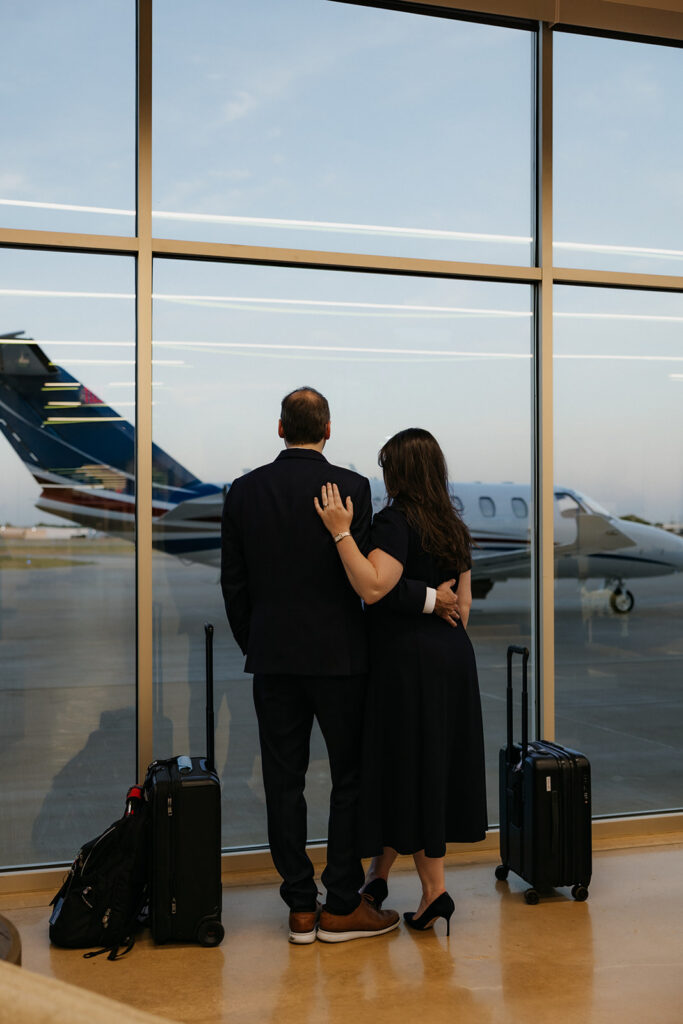 Couple looking out a window at a private airport in Dallas.