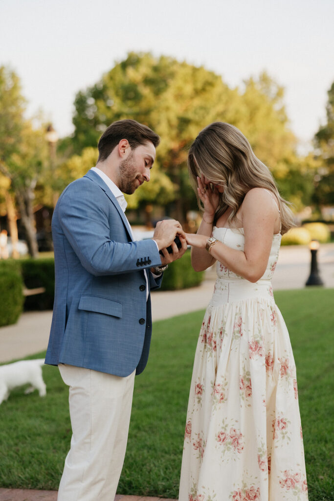 Man putting an engagement ring on his fiancée hand. 