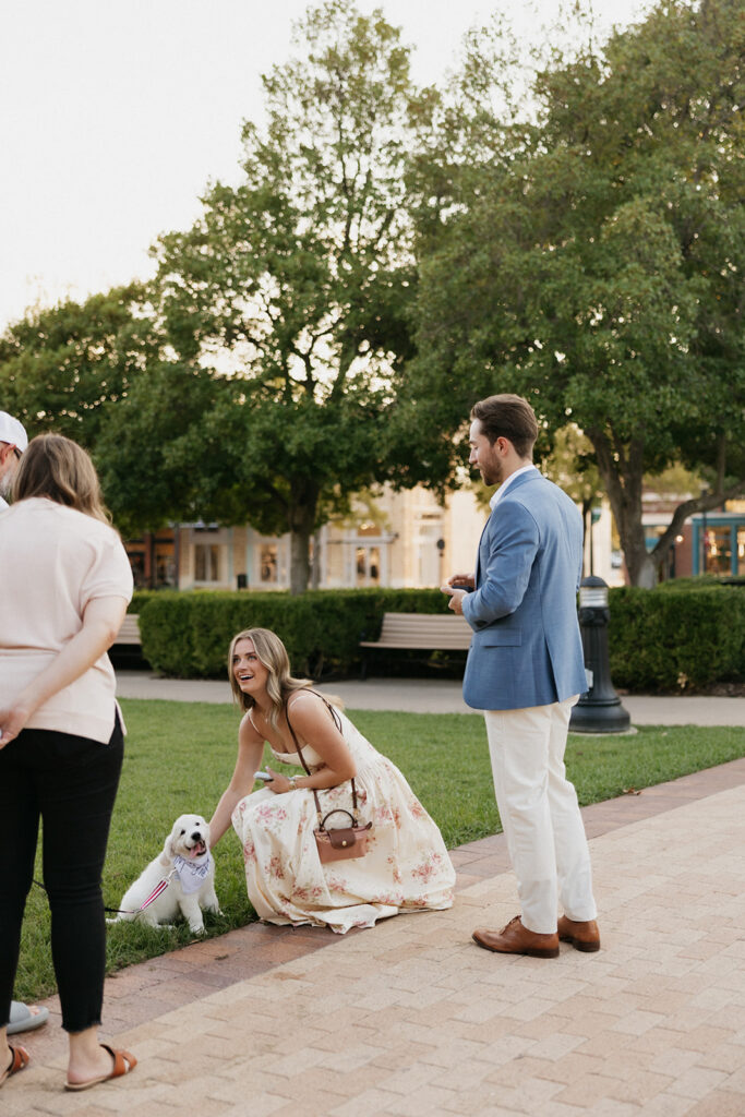 Surprise proposal ideas: a woman petting a puppy during a proposal.